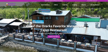 Waterfront Cajun restaurant with a purple banner and greenery in the background